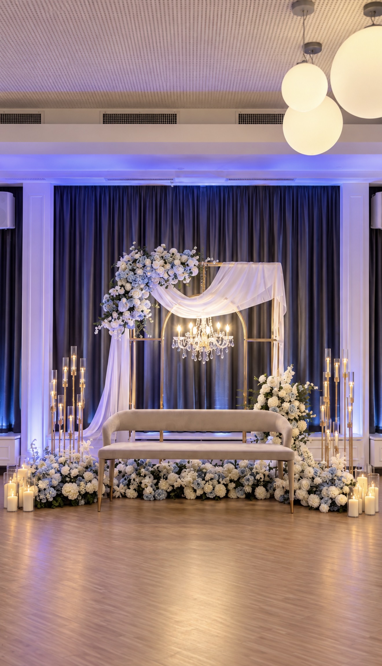Décor principal blanc et bleu avec structure dorée, lustre, fleurs et canapé