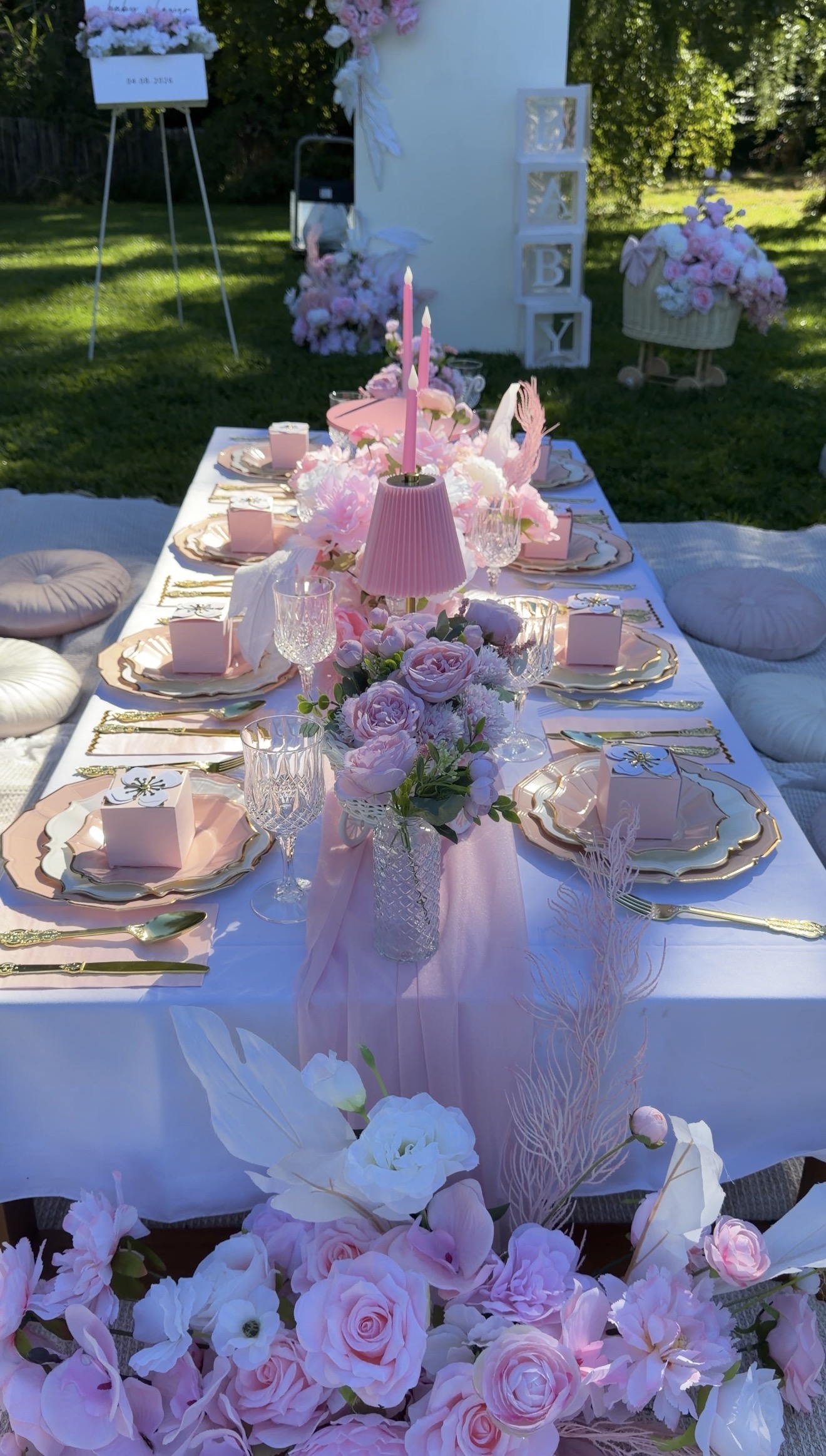 Table rose avec fleurs, vaisselle dorée et décoration extérieure
